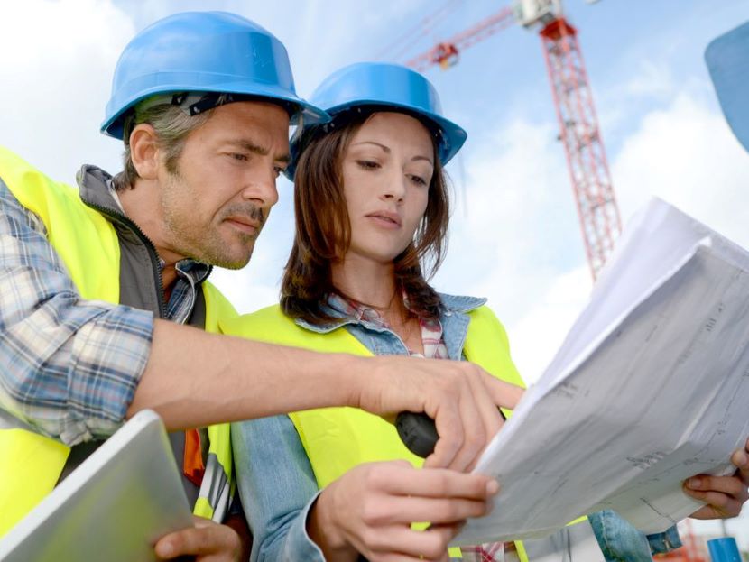 Architektin überprüft Baupläne auf einer Baustelle