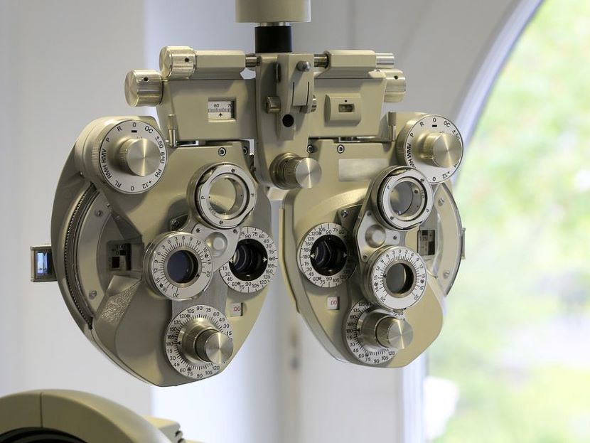 Augenoptikerin passt eine Brille bei einem Kunden an